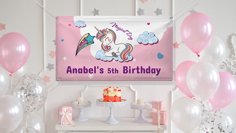 5th birthday banner in pink portraying a cute unicorn hung over the birthday cake table