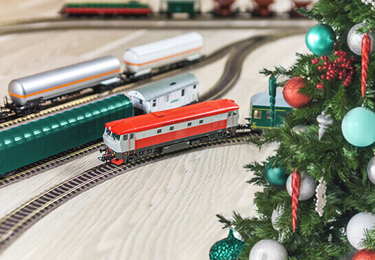 funny Christmas decorating idea with toy trains and railways on the floor