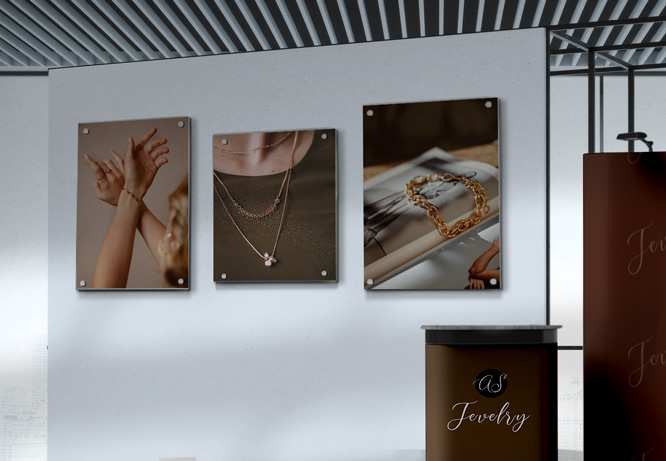 3 pictures of jewelry hung in a row on a trade show booth wall for decoration