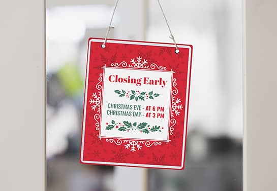 a red Christmas closing hours sign with green letters for a front door decoration