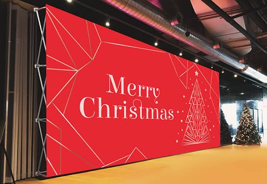 Red Christmas concert backdrop placed on a stage with the words Merry Christmas