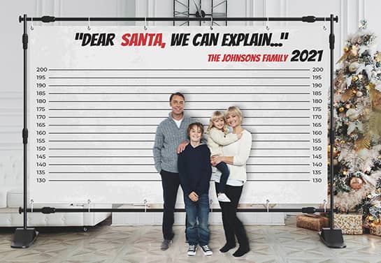Christmas party backdrop with a funny quote and a family posing in front of it