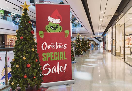 Red in-store Christmas special sale banner with Grinch
