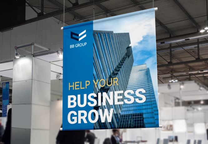 Hanging trade show graphics portraying a skyscraper and a note Help your business grow