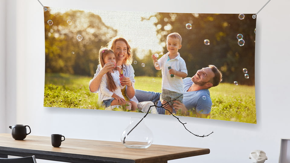 Large rolled canvas print in a hanging style with a family portrait mounted on a wall