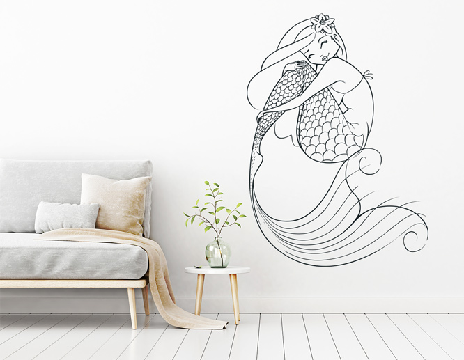 A living room vinyl wall art decal with a mermaid next to a sofa