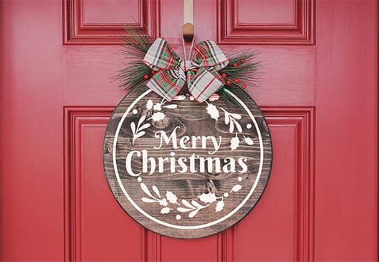 Round Merry Christmas sign made of foamboard material hanging on a door