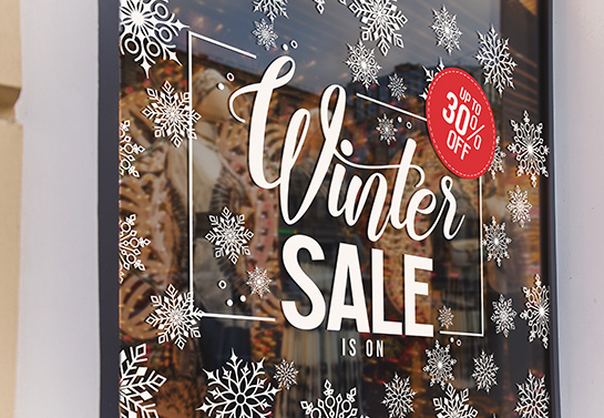 Window sign for winter sales decorated with white snowflakes