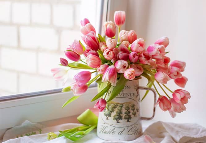 Vase of flowers near a window as a Valentine's Day decoration idea