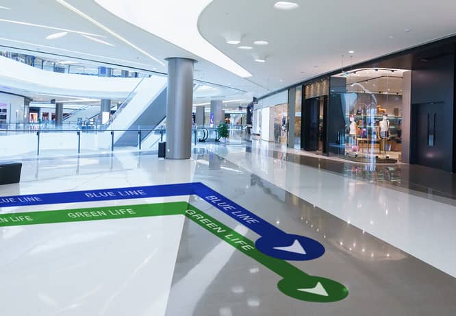 Expressive wayfinding flooring with blue and green arrows