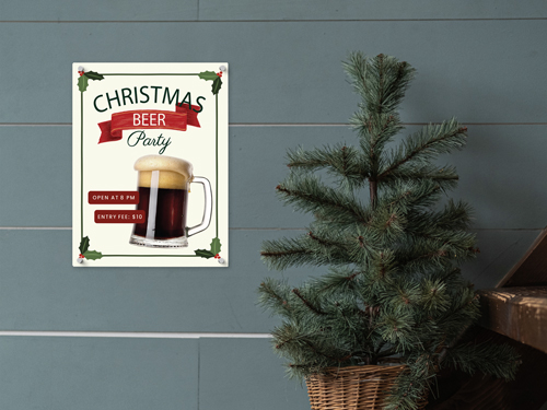 Aluminum Christmas beer party sign showing a frothy beer mug and event details, mounted on a wall next to a small Christmas tree.