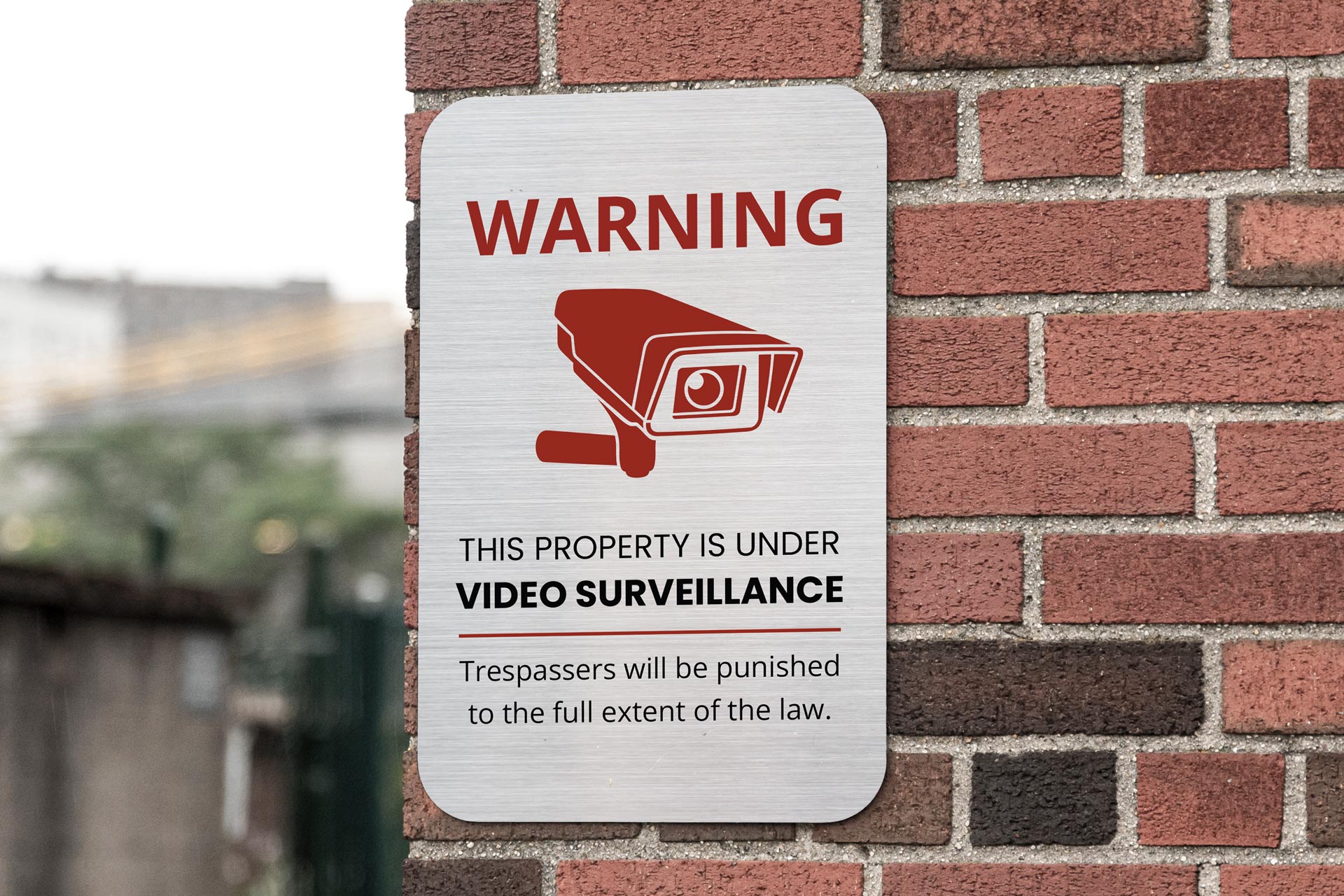 Brushed metal sign warning about the video surveillance.