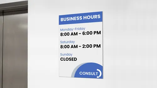 A gatorboard sign mounted on the wall showcasing a company's working hours.