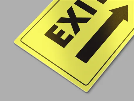 Vibrant reflective aluminium sign reading exit on a yellow background
