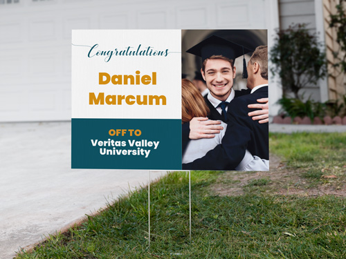 A yard sign with the image of a young graduate set up on the front yard.