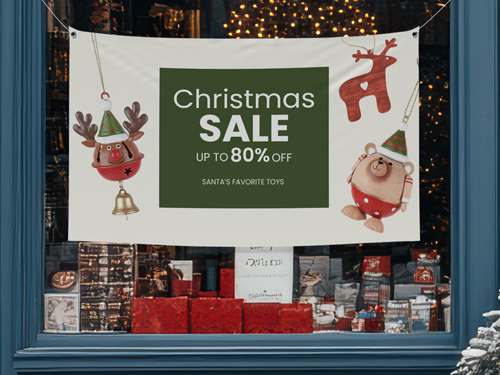 Christmas sale vinyl banner with festive toy illustrations and “Up to 80% Off” text hanging in a store window display.