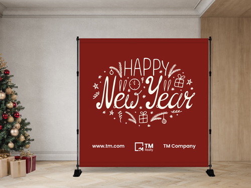 Red step and repeat banner with white “Happy New Year” design displayed beside a decorated Christmas tree.