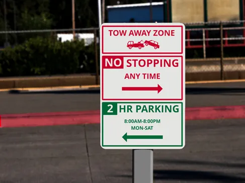 Informative metal signs installed outdoors notifying drivers of a tow away zone and parking