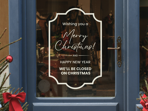 White Merry Christmas window vinyl lettering with holiday closure notice displayed on a blue storefront door.