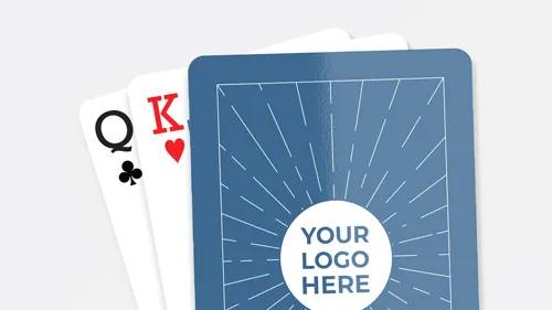 Customized playing cards with a blue back design featuring a placeholder for a logo, partially revealing a Queen of Clubs and King of Hearts