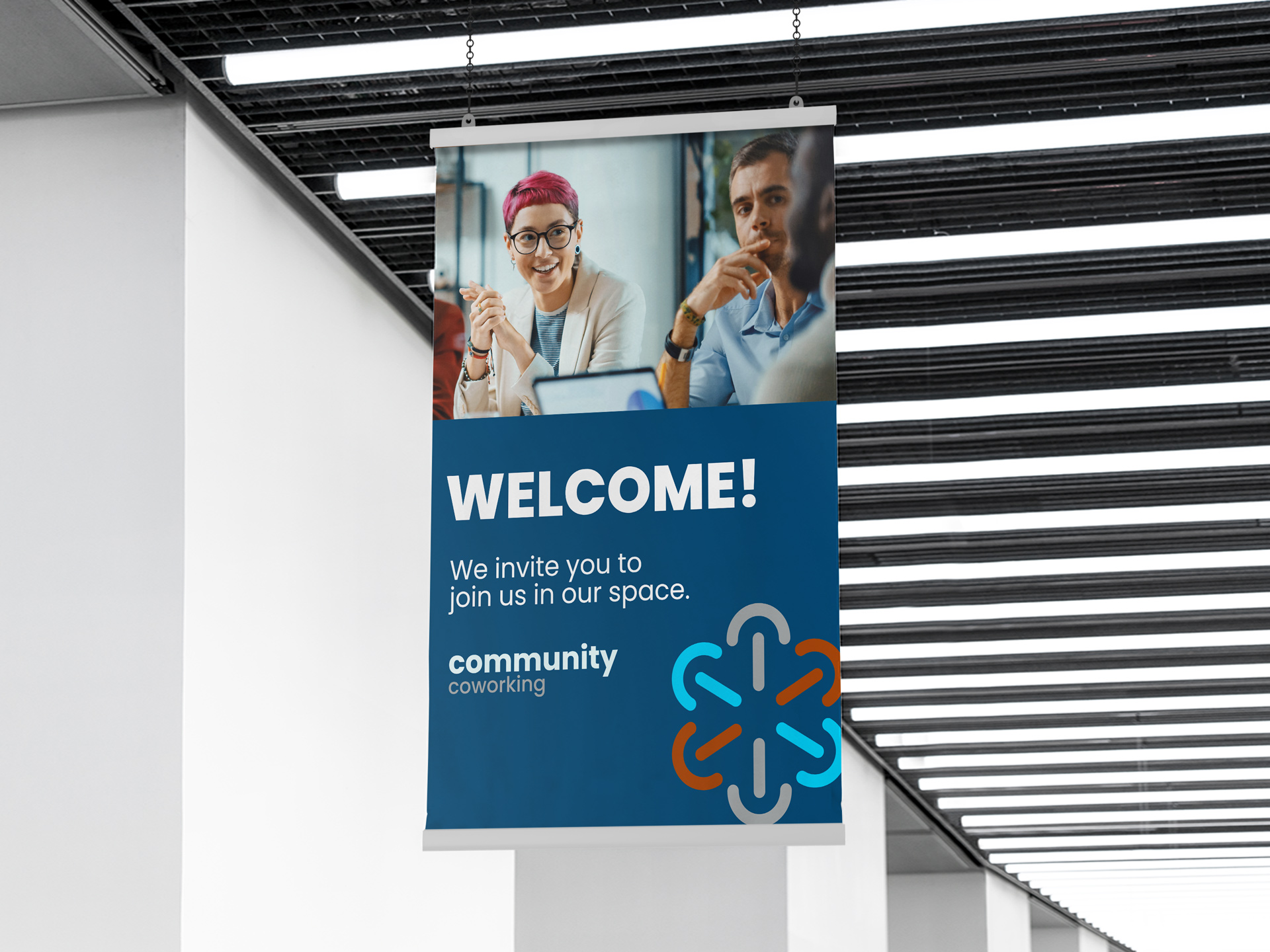 A promotional snap hanging poster is hanging from the ceiling and reads "Welcome! We invite you to join us in our space" against a blue background.