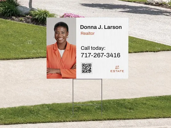 A custom yard sign promoting a realtor's services and her contact information.