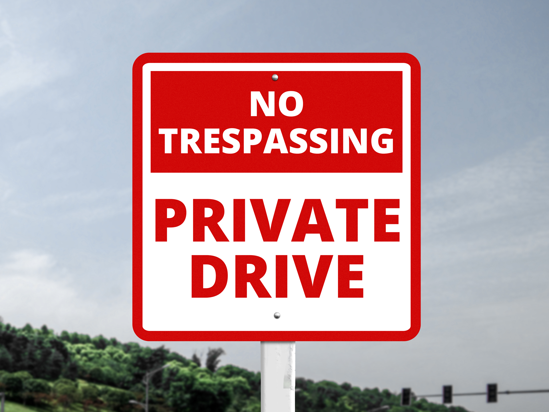 A red and white reserved parking sign reads "No Trespassing," "Private Drive"