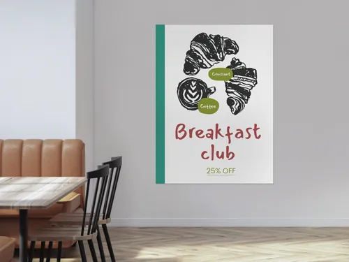 A restaurant styrene poster on the wall featuring an image of croissants and a text Breakfast Club. 