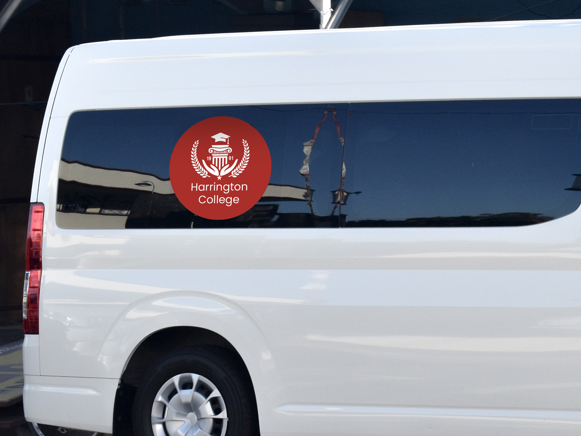 Van decal on a side window showcasing a college logo