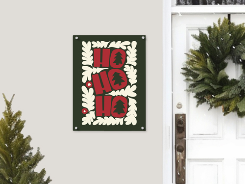 Ho Ho Ho Christmas aluminum wall sign with red lettering and festive leaf border displayed near a decorated front door.
