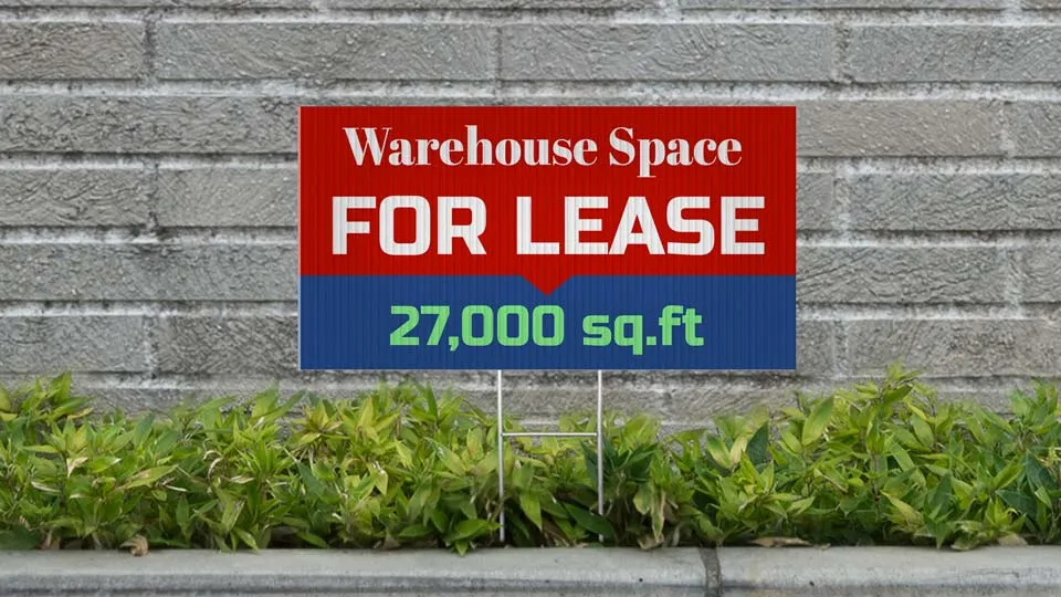 Warehouse For Lease sign in red and blue.
