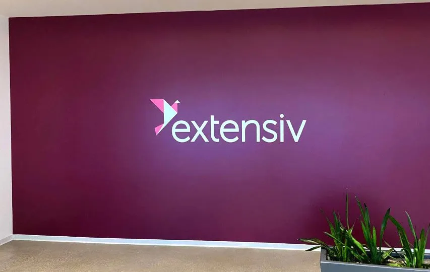 Branding office wall decal with the company name and logo on a purple background.