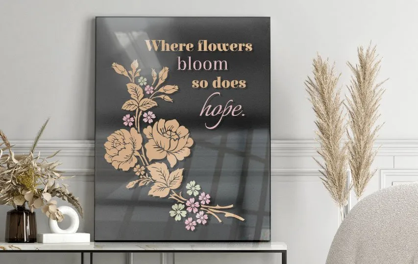 A black transparent acrylic signs with a floral design and motivational quote.