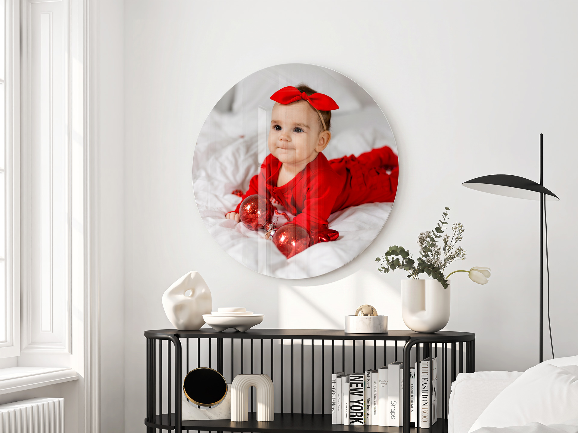 A round acrylic wall photo print picturing a smiling baby girl.