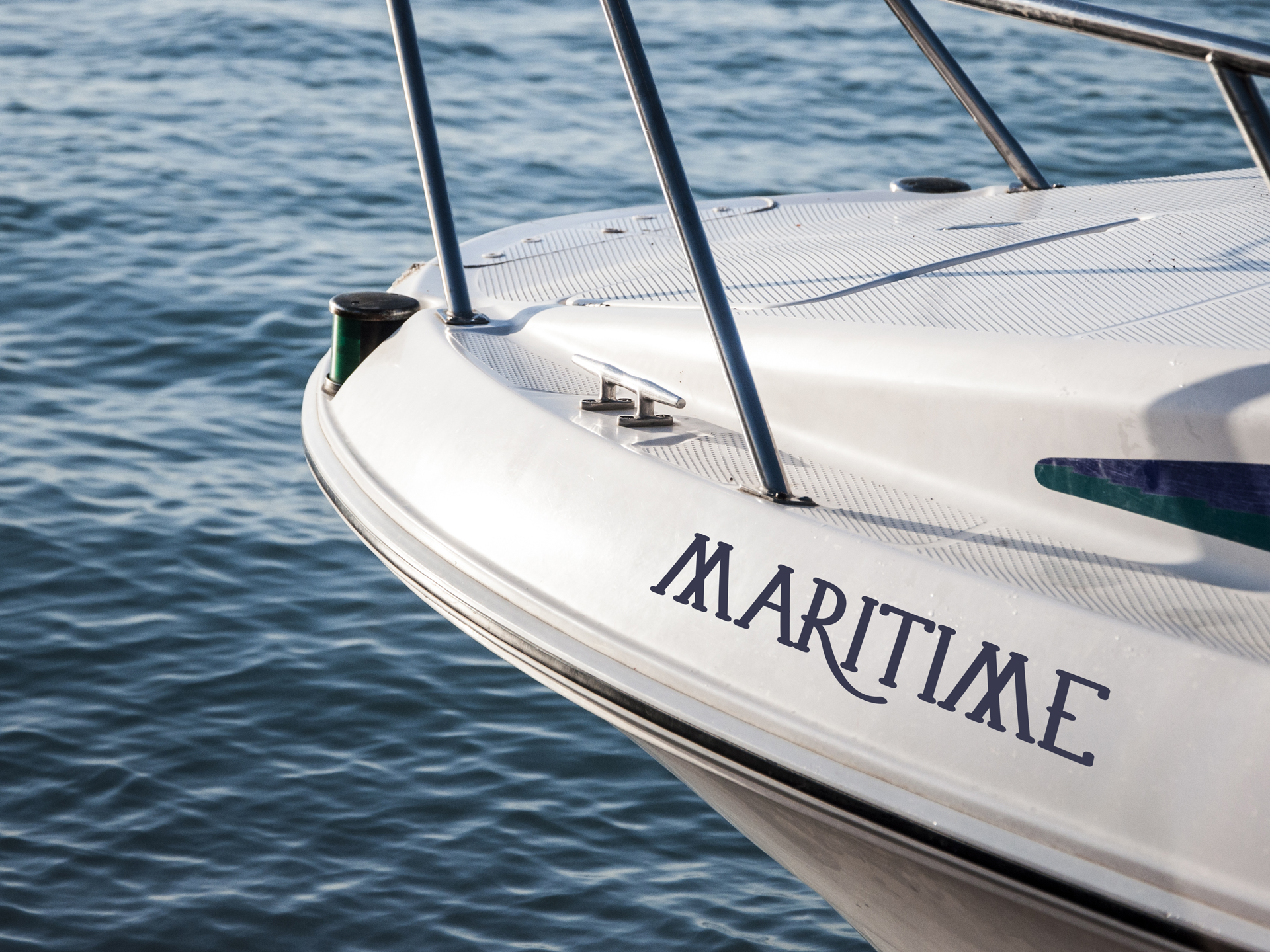 Cursive navy MARITIME lettering marks the bow of a docked boat.