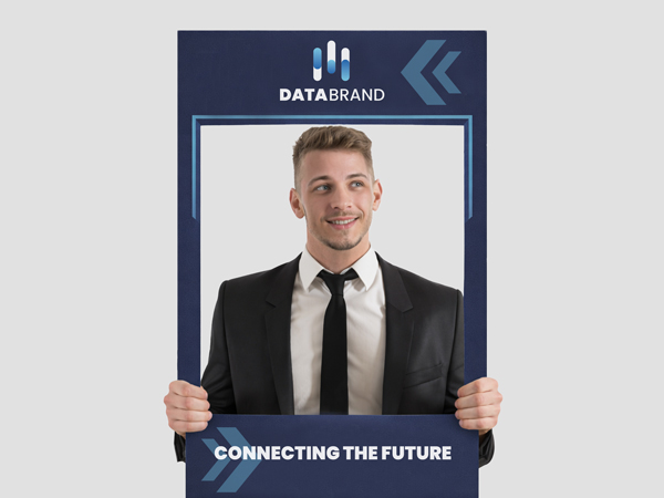 An employee holding up a company branded selfie frame posing for a photo.