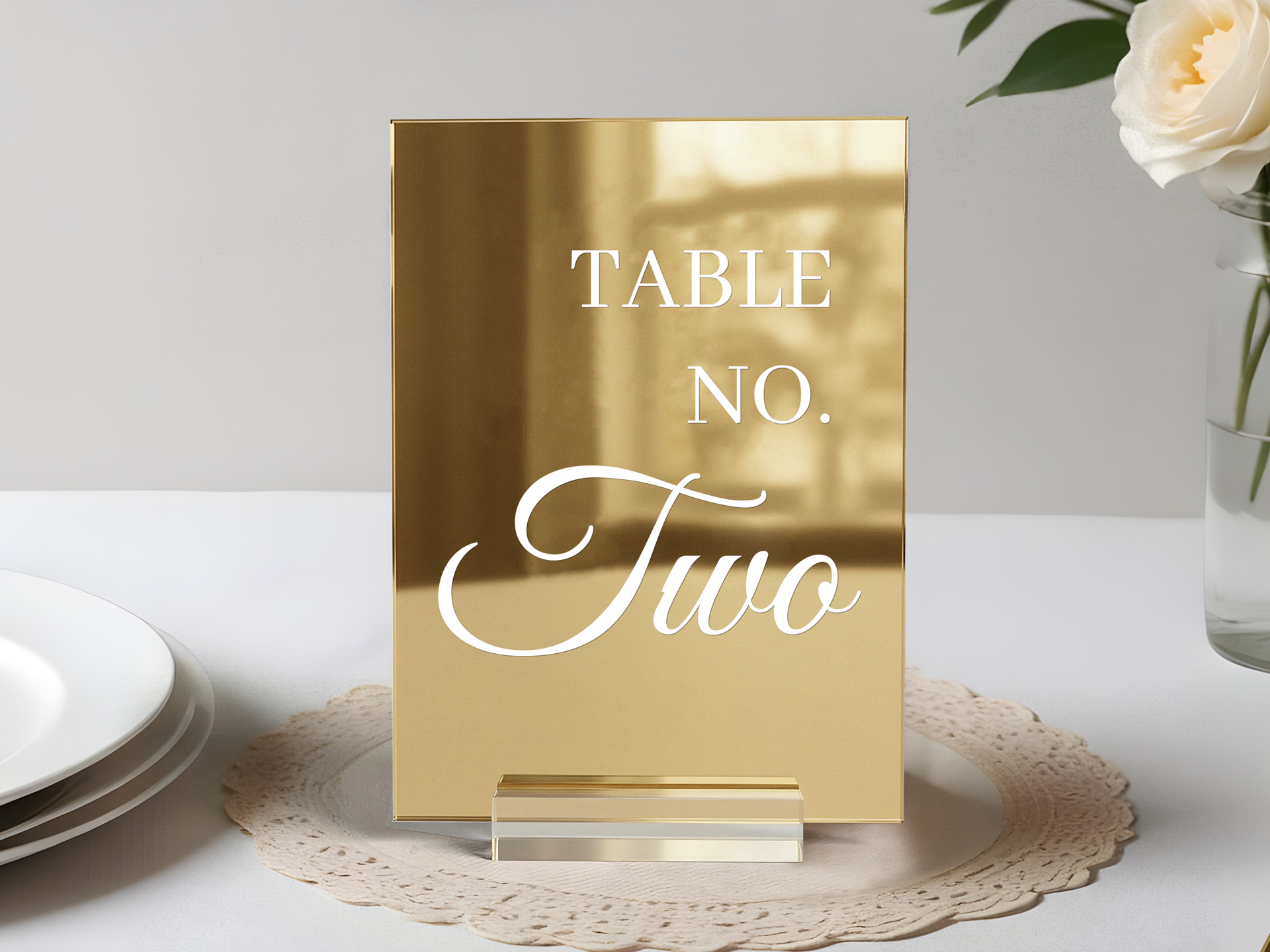 Gold acrylic table number reading Table No. Two on an elegant table setting with a rose