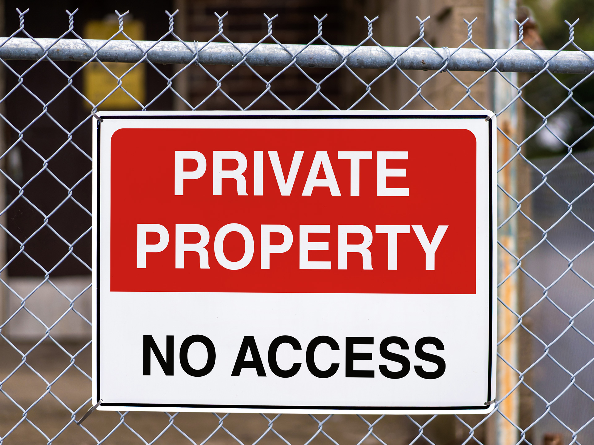 Metal outdoor sign installed on a fence with Private property no access messsaging.