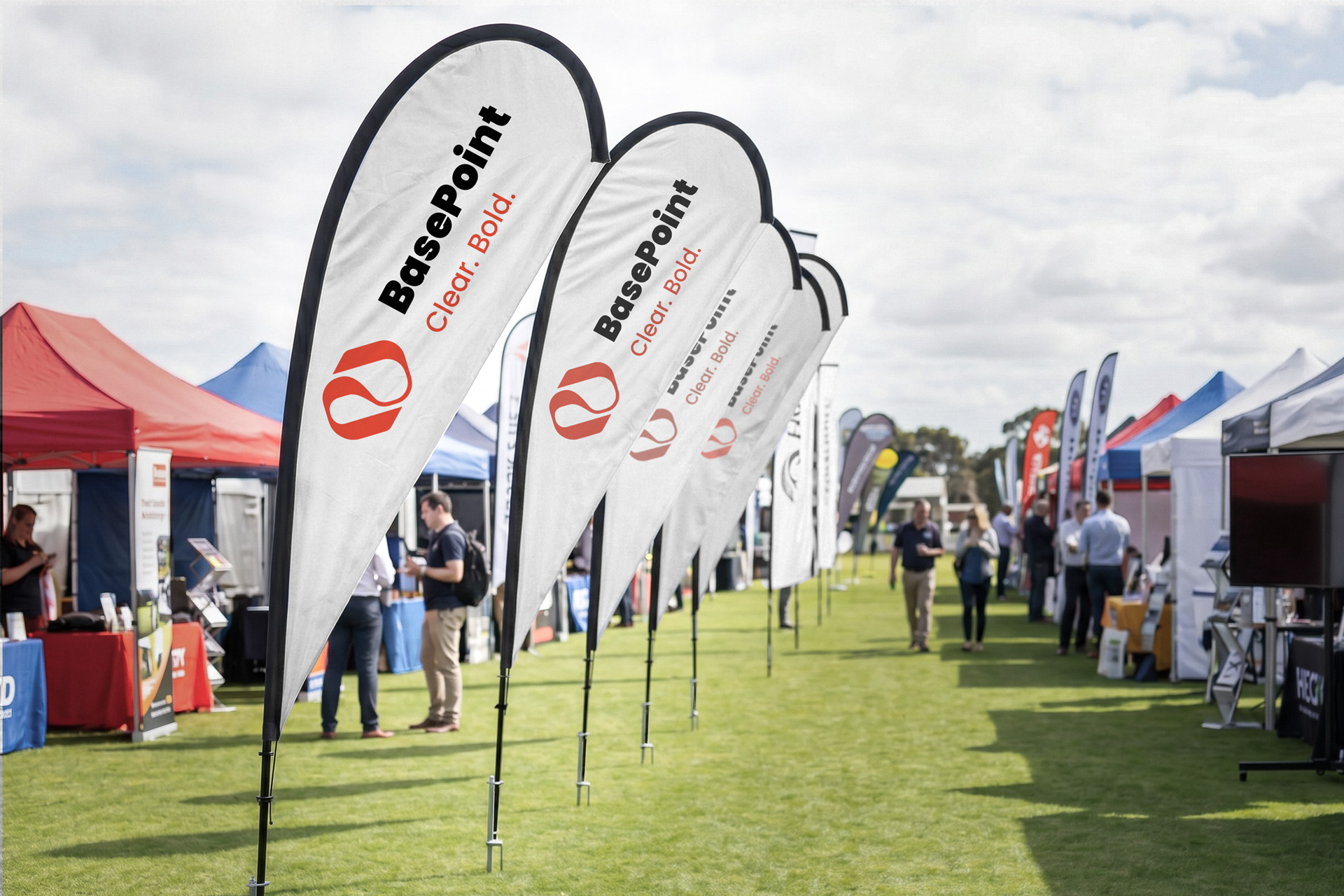 Custom teardrop flags printed with a company logo for an outdoor business event.