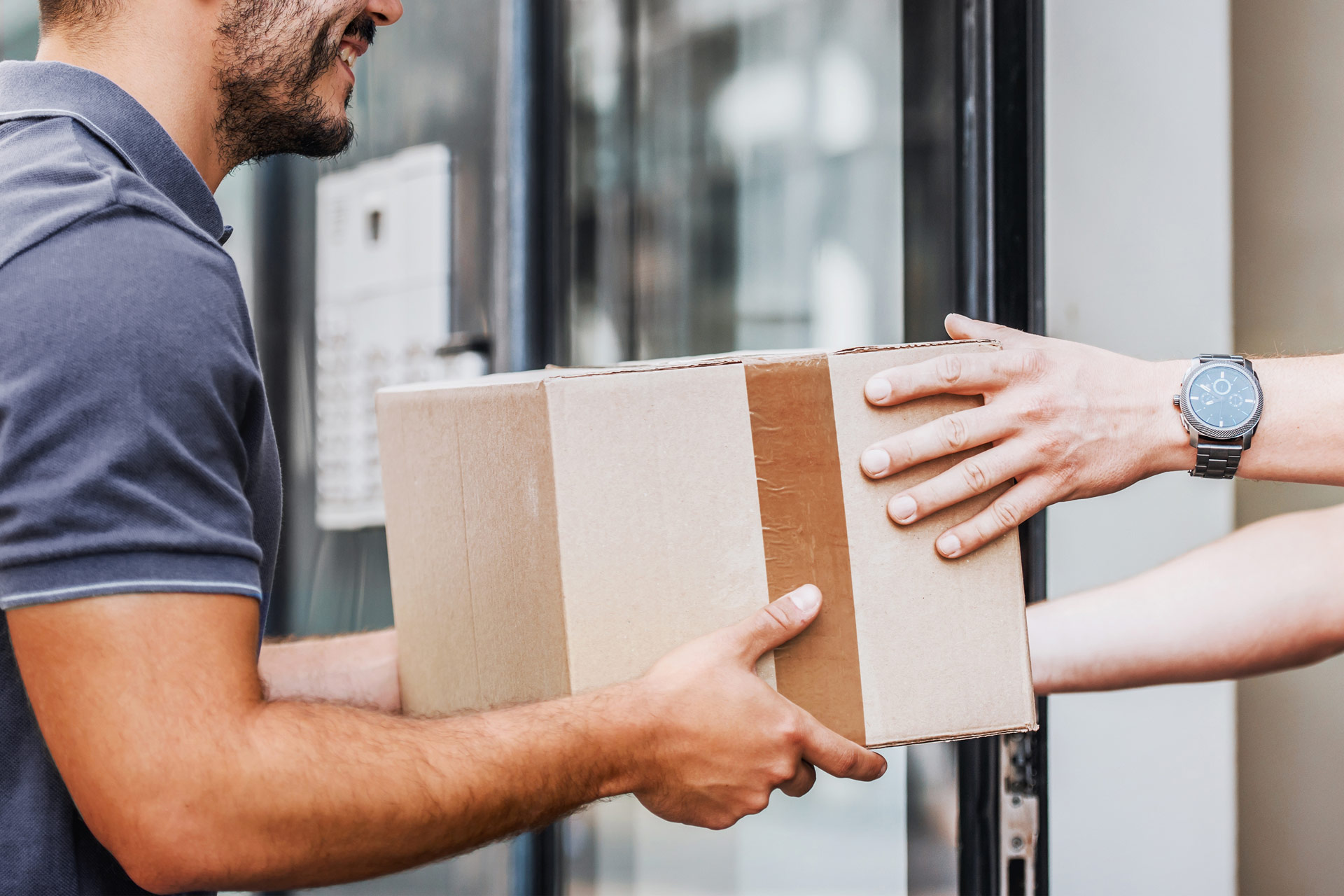An image of a delivery person handing over a package to a recipient.