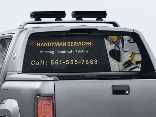 Truck rare window decal announcing handyman services and contact information.