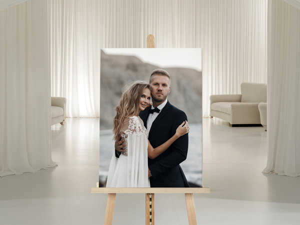 Wedding photo printed on a wooden panel displayed on an easel in a bright, minimalist studio setting.